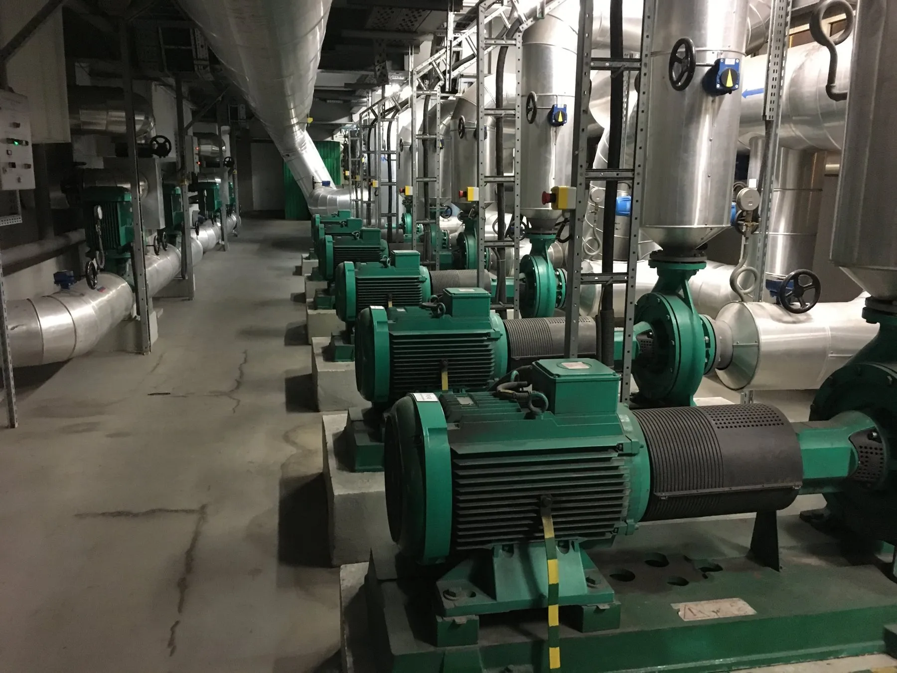 Row of motor-driven centrifugal pumps in a mechanical room